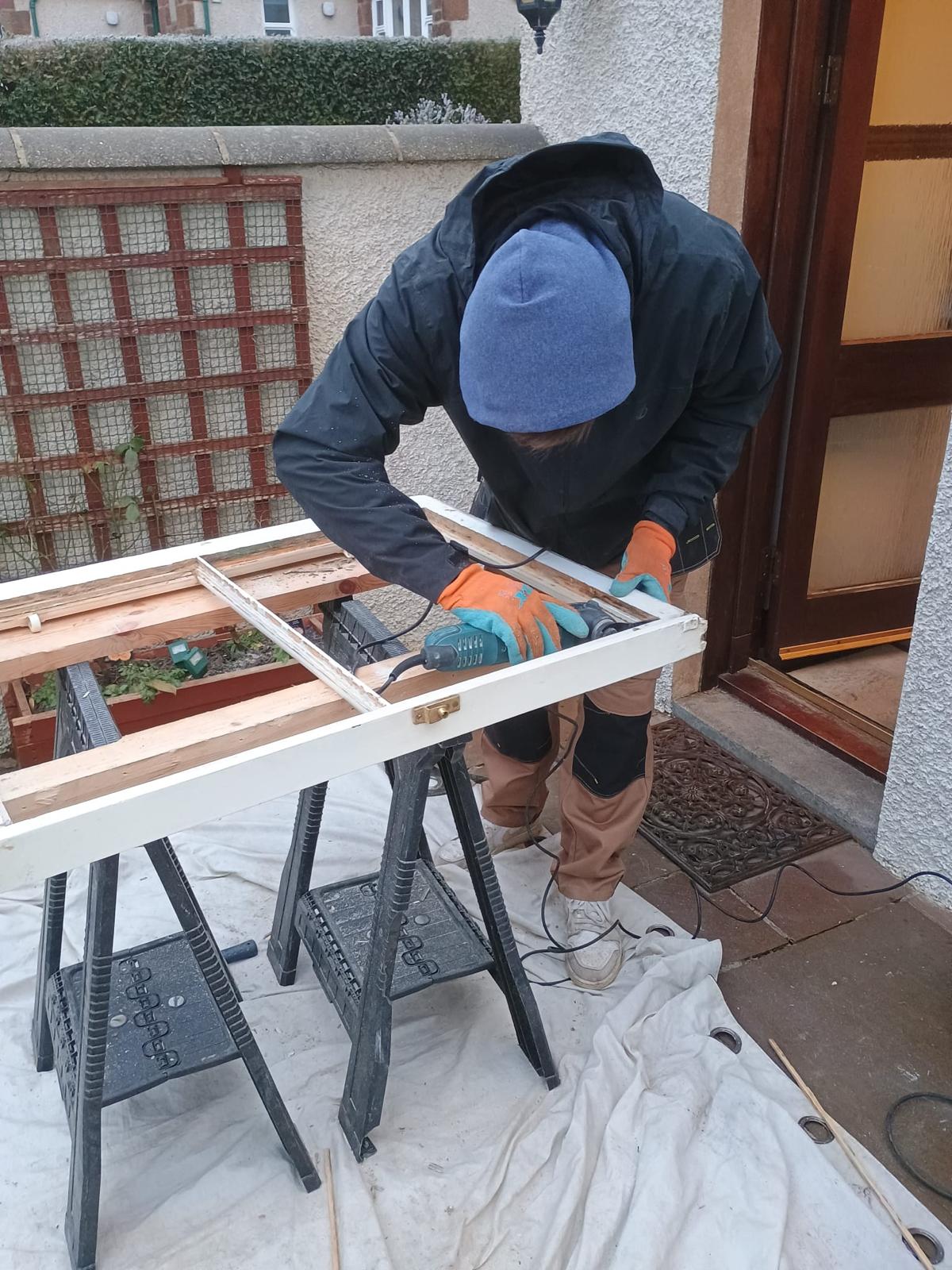 Joiner carrying out timber repairs to a traditional sash and case window